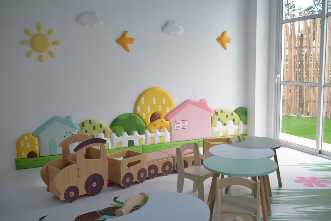 Salón con mesas pequeñas y un tren de madera
