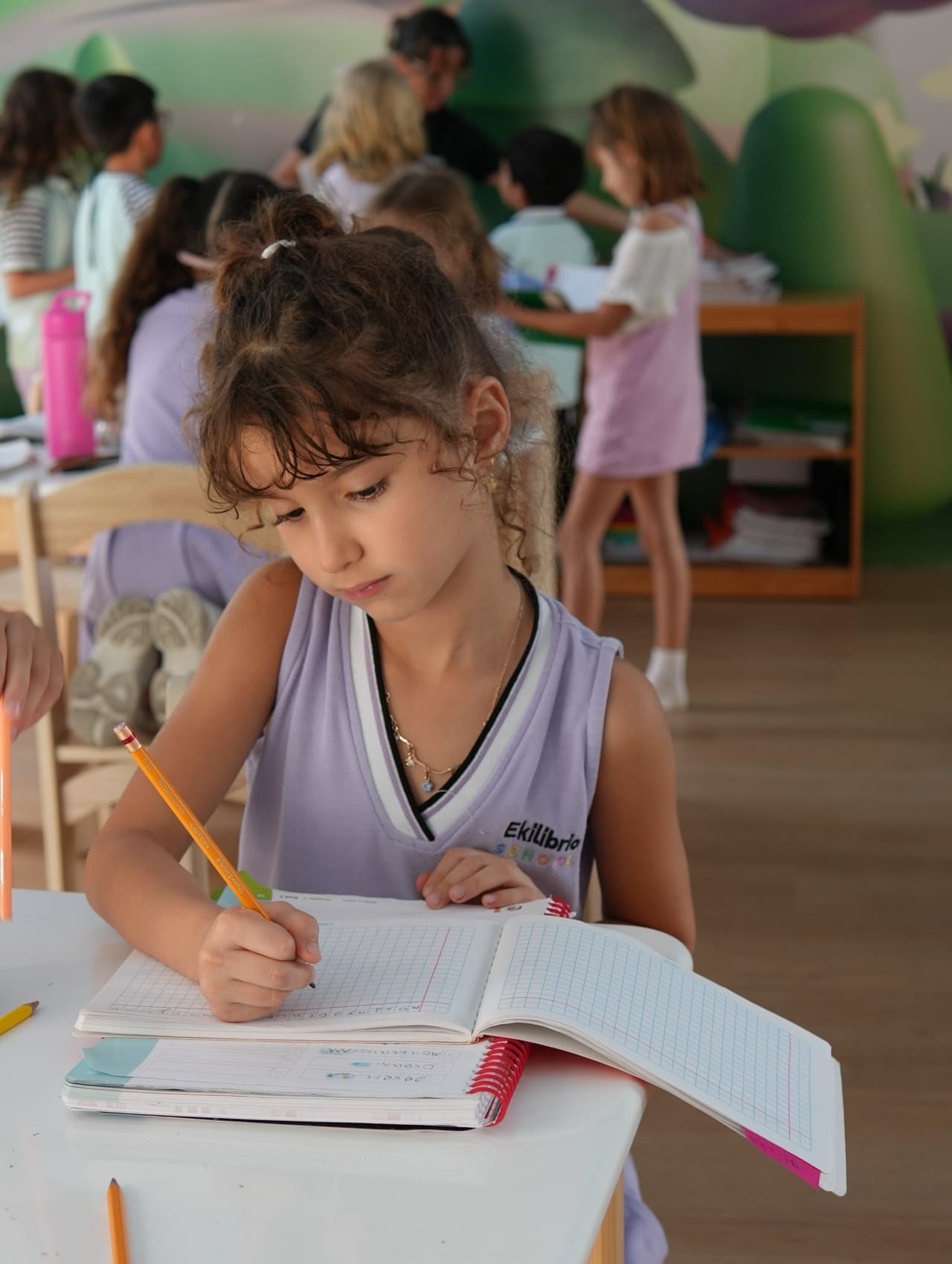 Una alumna escribe en su cuaderno en el salón