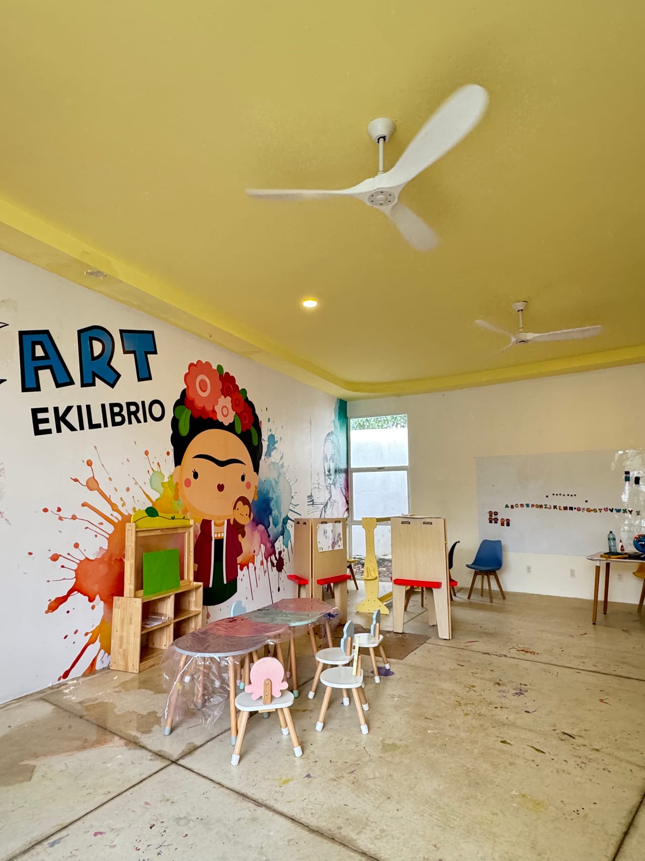 Salón de arte con un mural de Frida Kahlo