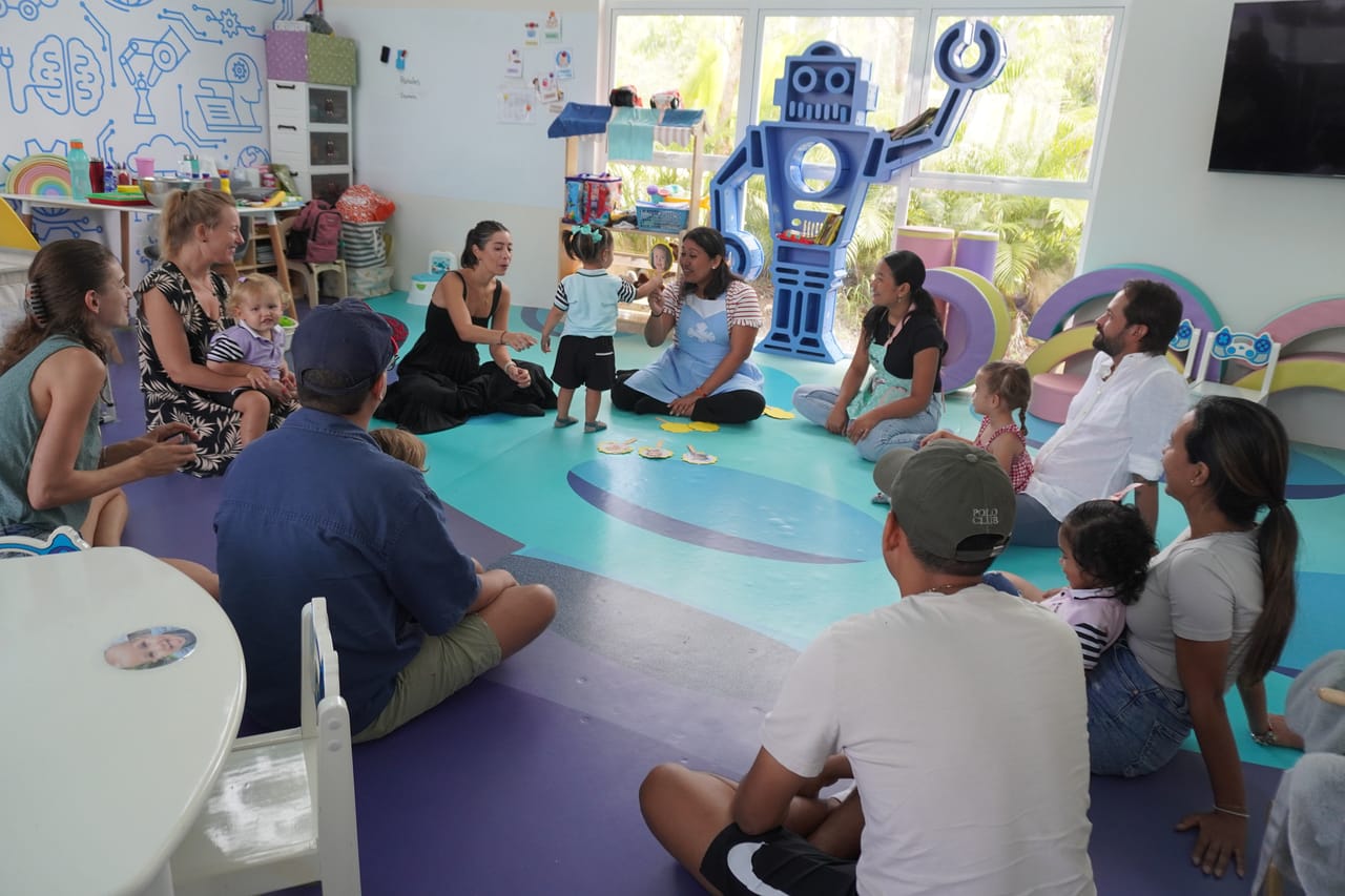 Familias sentadas en círculo con sus hijos en un salón