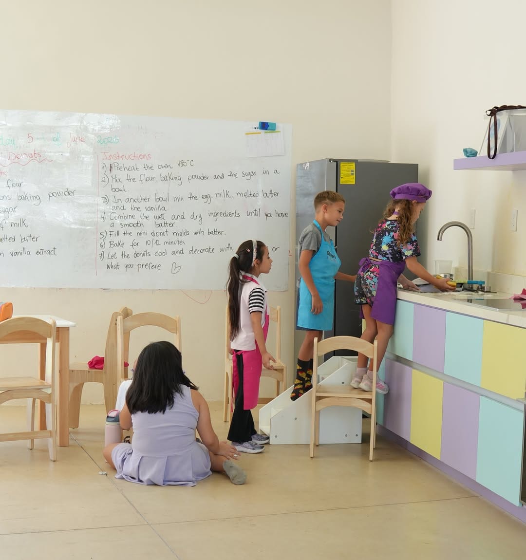 Niñas y niños cocinan en la cocina de la escuela